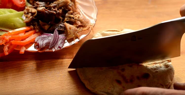 Pita rozřízl na polovinu.