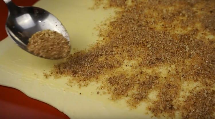 Поръсете тестото със смес от канела, захар и бадеми.