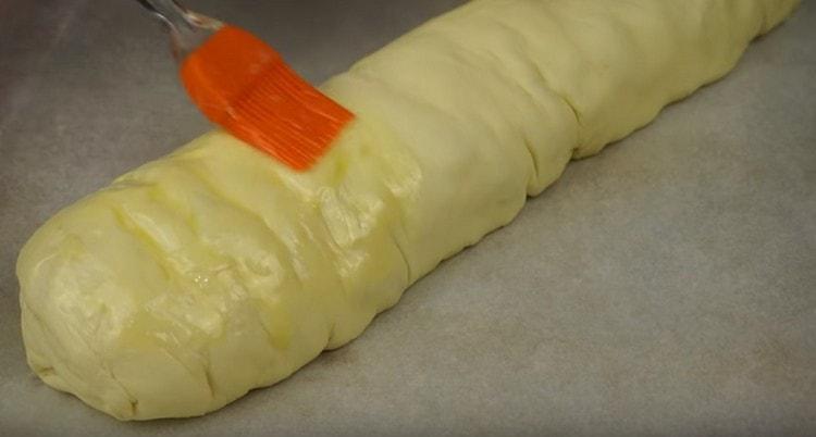 Прехвърляме продукта в тава за печене, намазваме с останалото масло.