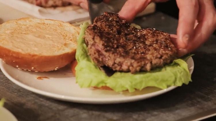 Um einen Burger zuzubereiten, legen Sie die Pastete auf das Brötchen