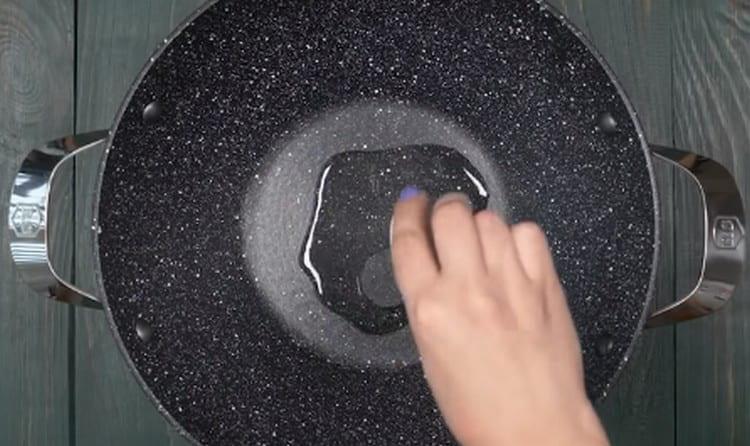 încălziți tigaia wok cu ulei vegetal.