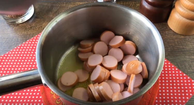 Couper les saucisses en cercles et les répartir dans une casserole.