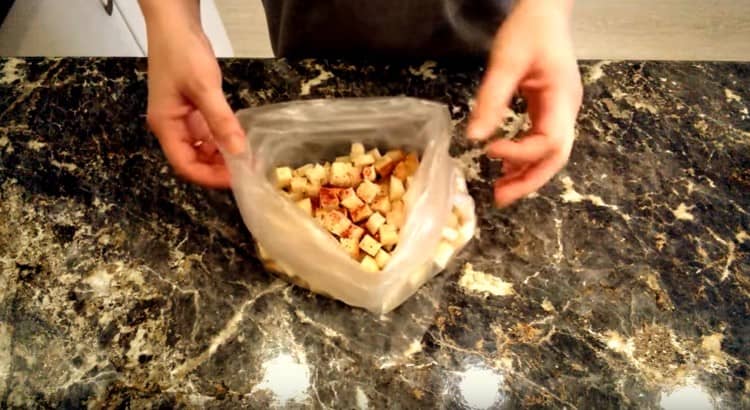 Wir legen die Würfel des Brotes in eine Tüte und mischen sie mit Salz und Gewürzen