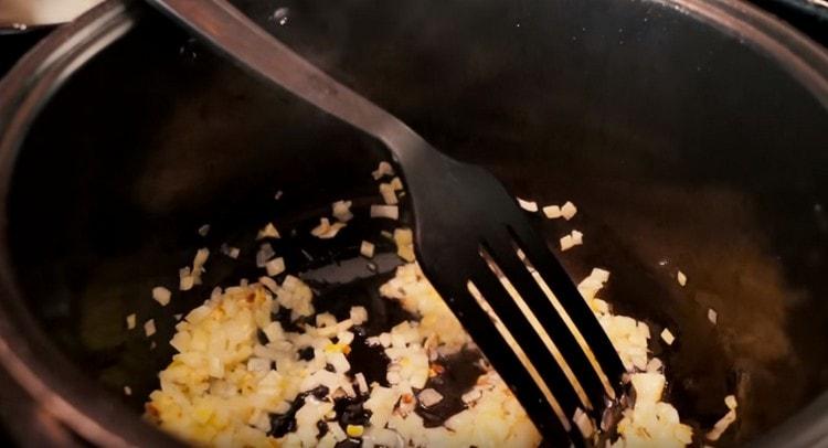 Gehackte Zwiebeln in einer Mehrkochschüssel anbraten.