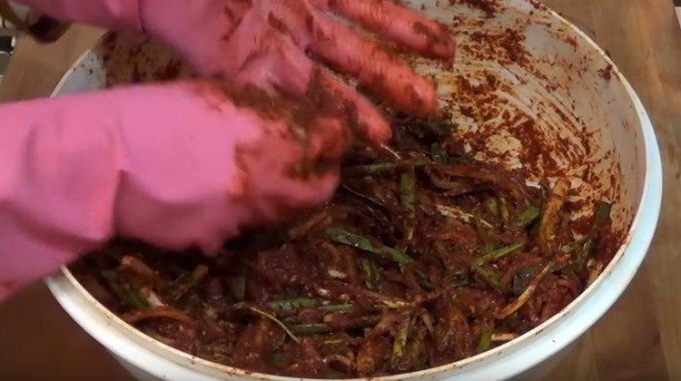 Разпределяме дайкона и лука в острата маса.