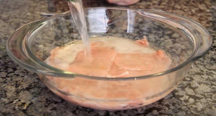 Слагаме месото в купа и заливаме с минерална вода.