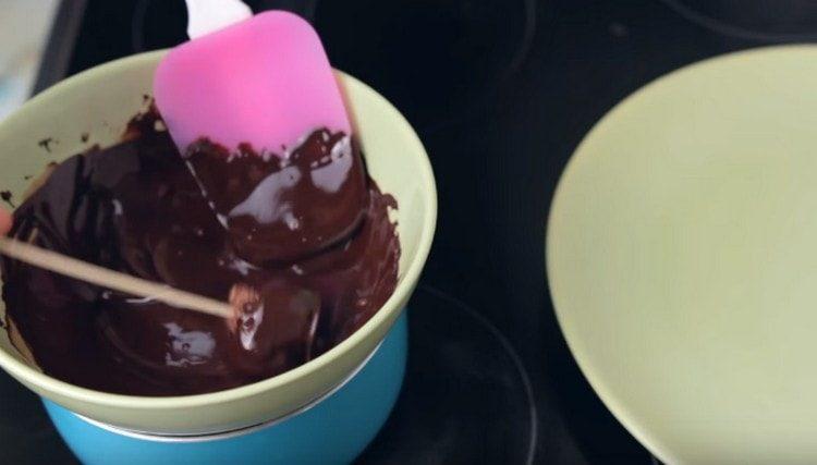 Vi lægger hvert stykke på et spyd og dypper det i chokolade.