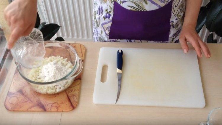 Adăugați făina în masa de varză.