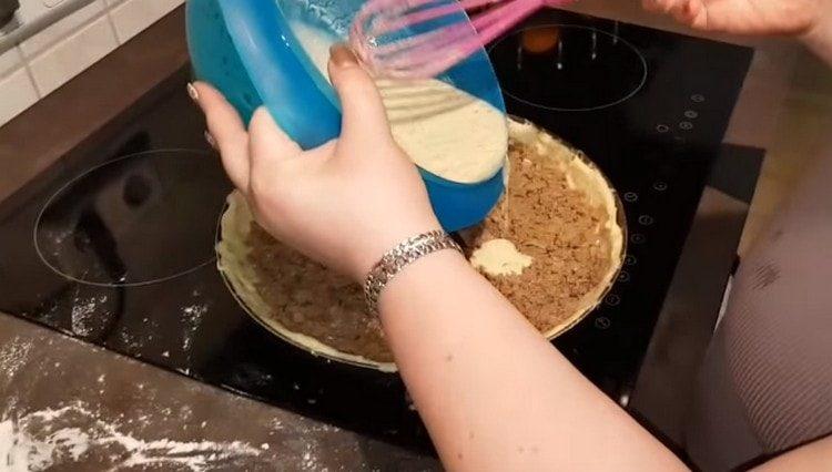 On étale la pâte sur la pâte, on la remplit de crème aigre et du mélange d'oeufs.