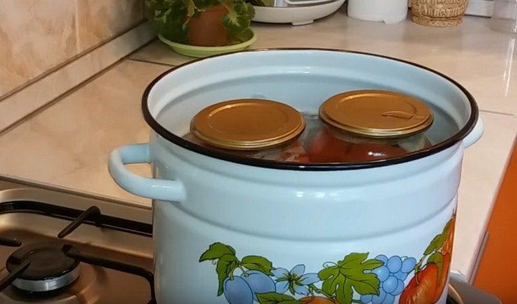 Sterilizăm borcanele cu roșii.