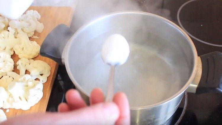 Доведете водата до кипене в тиган, осолете я.