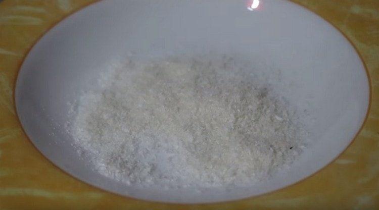 Pentru a presă desertul, luăm zahăr pudră și fulgi de nucă de cocos.