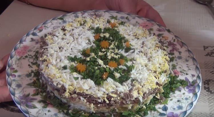 Pynt svinekødssalat med revet æg og urter.