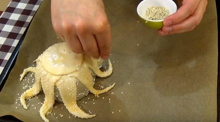 Saupoudrer la pièce de travail avec des graines de sésame.