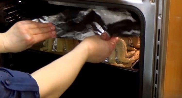 Mettez la plaque à pâtisserie au four, recouvrez les pieuvres de papier d'aluminium.