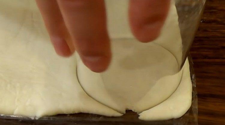 Nous coupons des cercles dans la pâte avec un verre.