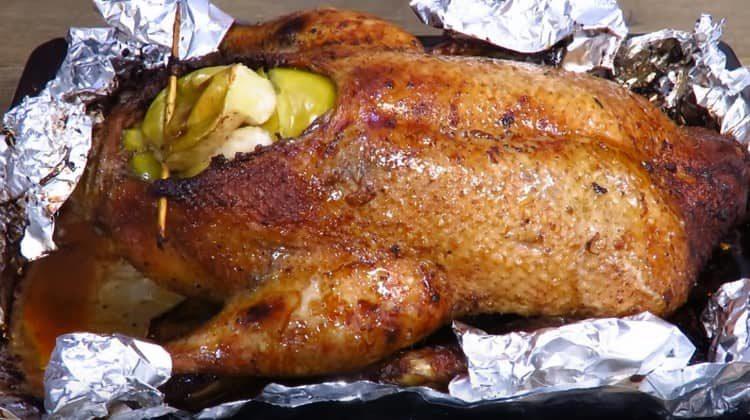 Pentru ca picioarele și aripile raței să nu fie arse, le învelim în folie.