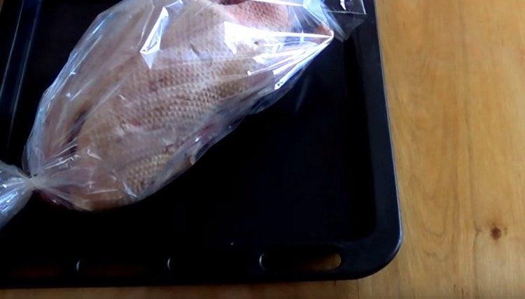 pune pasărea pe o foaie de copt și coace rața în mânecă în cuptor.