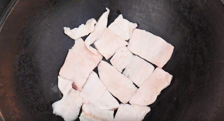 В долната част на казана разположете дебел слой нарязана мазнина.