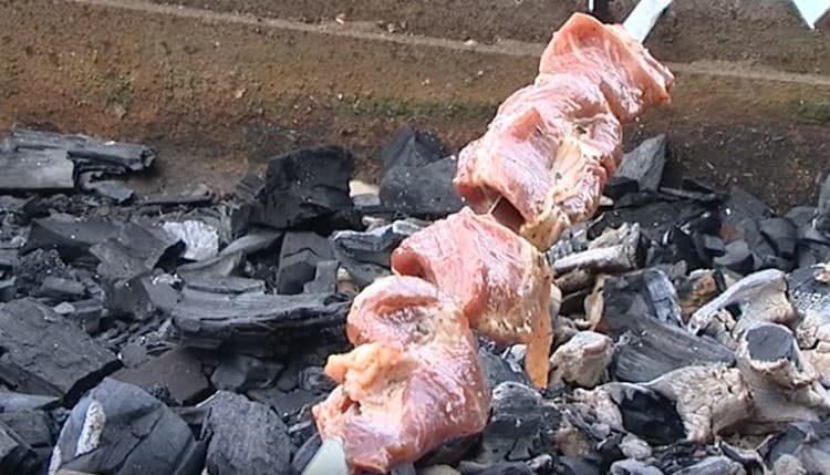 Den Spieß auf den Grill legen.