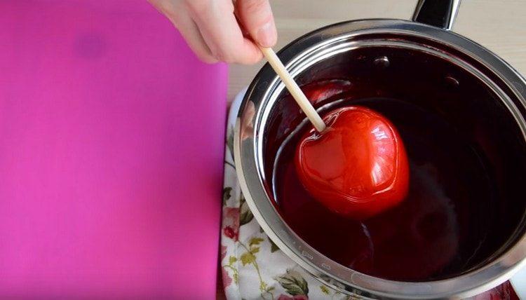 Mergulhe as maçãs no caramelo.