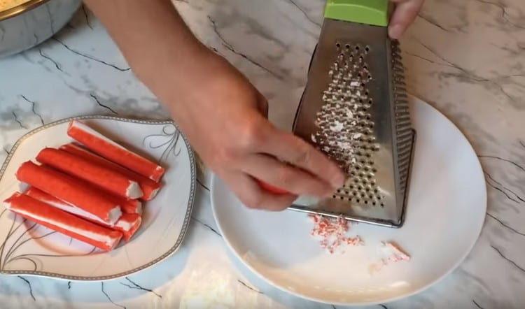 Trois bâtons de crabe séparément sur une râpe fine.