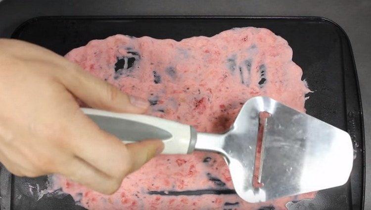 Cu o spatulă, distribuiți masa cu un strat subțire pe o foaie sau o tavă de copt.