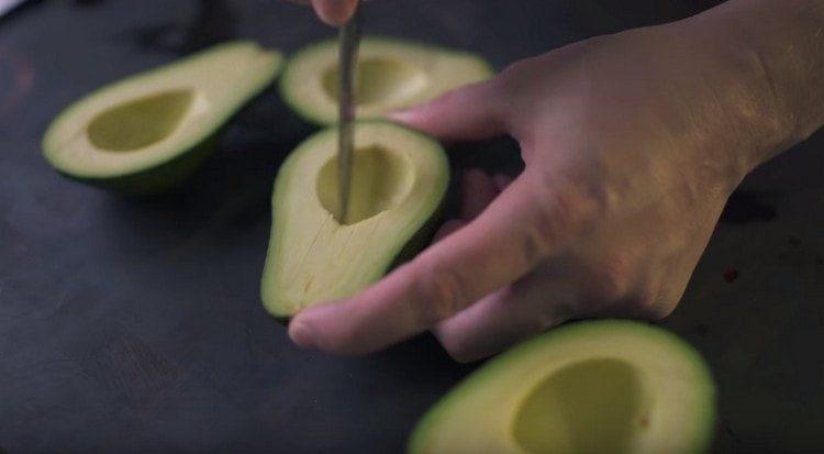 Facem tăieturi pe carnea unui avocado.