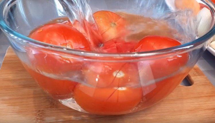 Efter kogende vand fyldes tomaterne med koldt vand.