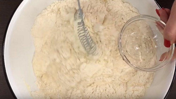 Fügen Sie ein wenig Milch und Pflanzenöl zu den trockenen Zutaten hinzu,