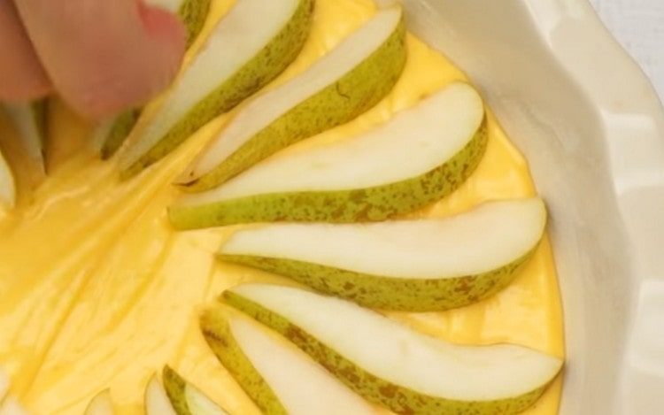 Em cima da massa, coloque lindamente as fatias de peras.