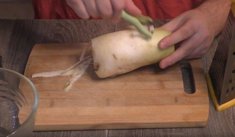 Curățăm daikon de coaja.