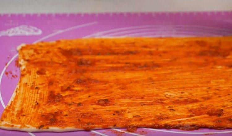 se rulează patiseria de puf terminată, se unge cu sos de roșii.