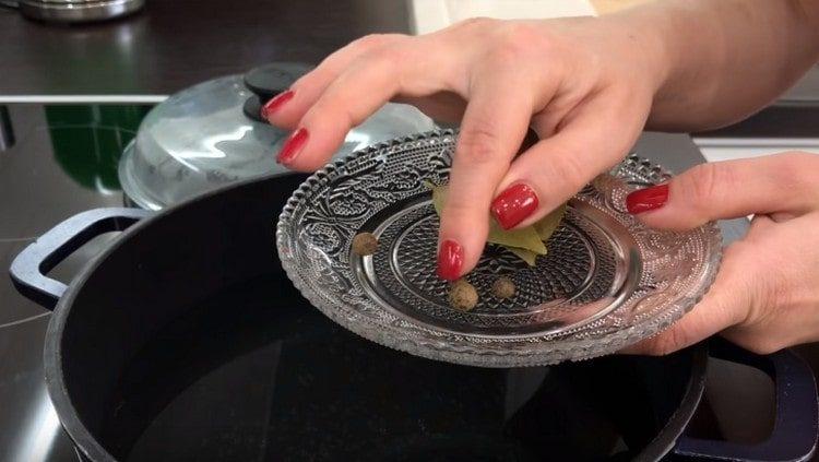 Wasser in die Pfanne gießen, erwärmen lassen, Lorbeerblatt und Pfefferkörner dazugeben.