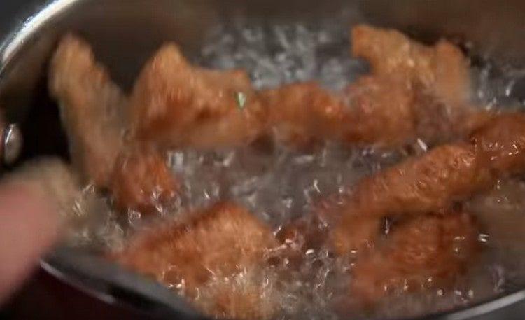 Fry ang baboy sa langis hanggang sa ginintuang kayumanggi.