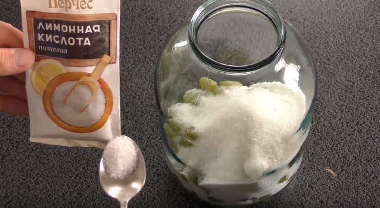 Riempiamo l'uva in un barattolo, aggiungiamo zucchero e acido citrico.
