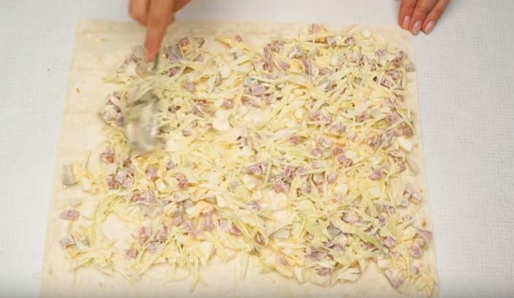 distribuiți umplutura pe o foaie de pâine pita.