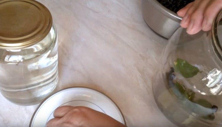 Слагаме карамфил, черешови листа в чист буркан.