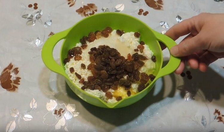 Nous mélangeons du fromage cottage avec du sucre, des œufs. ajoutez les raisins secs.