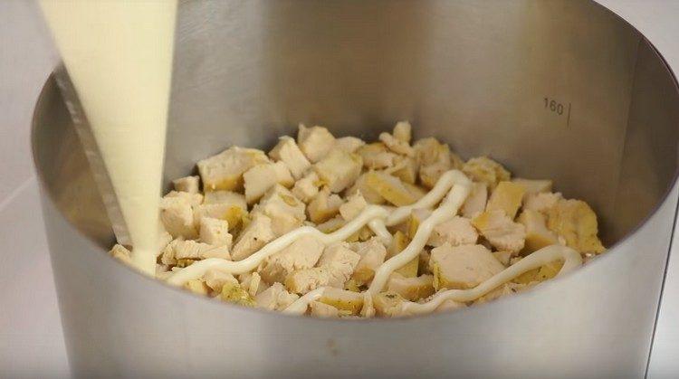 Primul strat de salată se face piept de pui, uns cu maioneză.