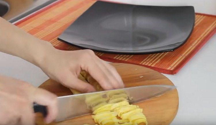 Wir rollen Pfannkuchen mit einer Rolle und schneiden.