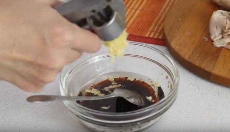Knoblauch zu Essig, Sojasauce und Pflanzenöl pressen.