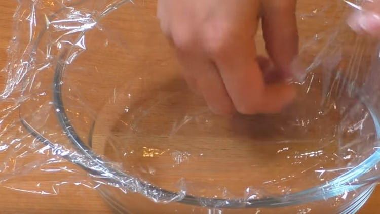 We cover the form for the preparation of salad with cling film.