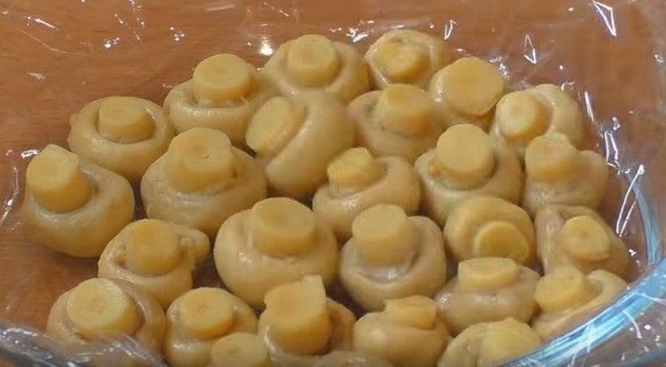 put the mushrooms with their caps down on the bottom of the form.