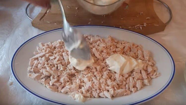 À partir de la poitrine de poulet, nous faisons la première couche de salade, graissez avec de la mayonnaise