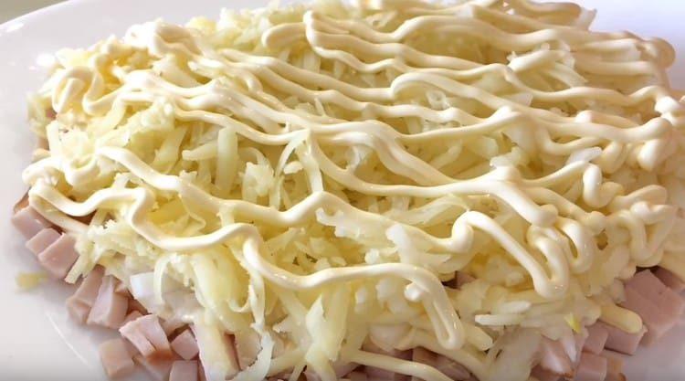 luego rallar las papas hervidas, hacer una rejilla de mayonesa.