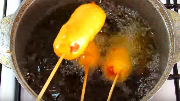 Isawsaw ang mga sausage sa batter at magprito sa langis ng gulay.