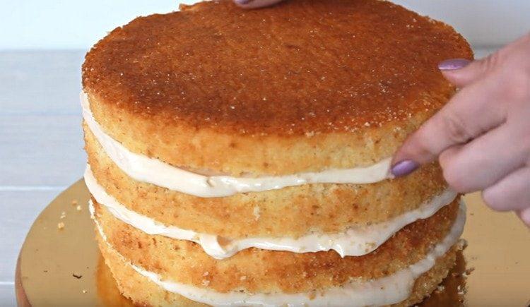 Nous collectons le gâteau en badigeonnant les gâteaux de crème à la fraise.