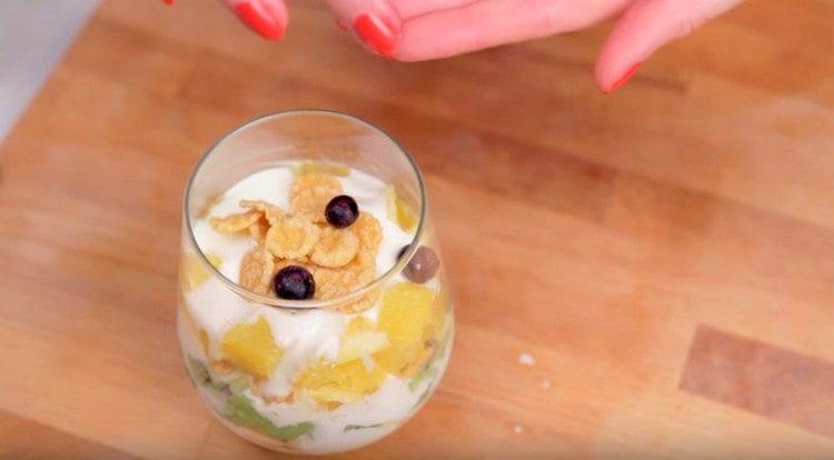 אנו מקשטים סלט פירות בדגנים ואוכמניות.