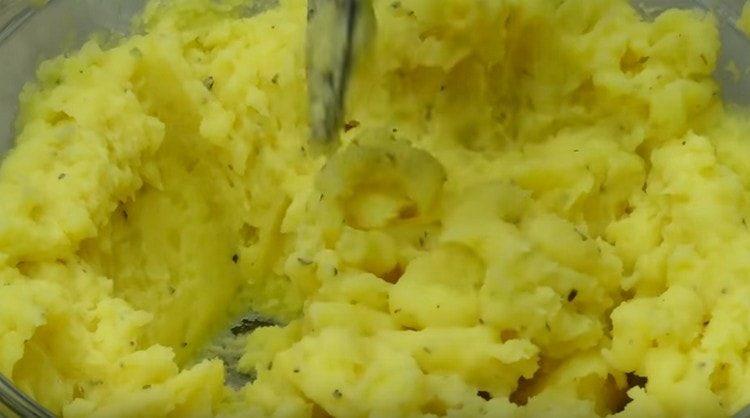 Добавете провансалските билки, разбъркайте картофената маса.